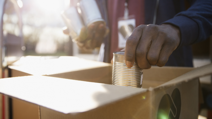 Man filling box with canned goods